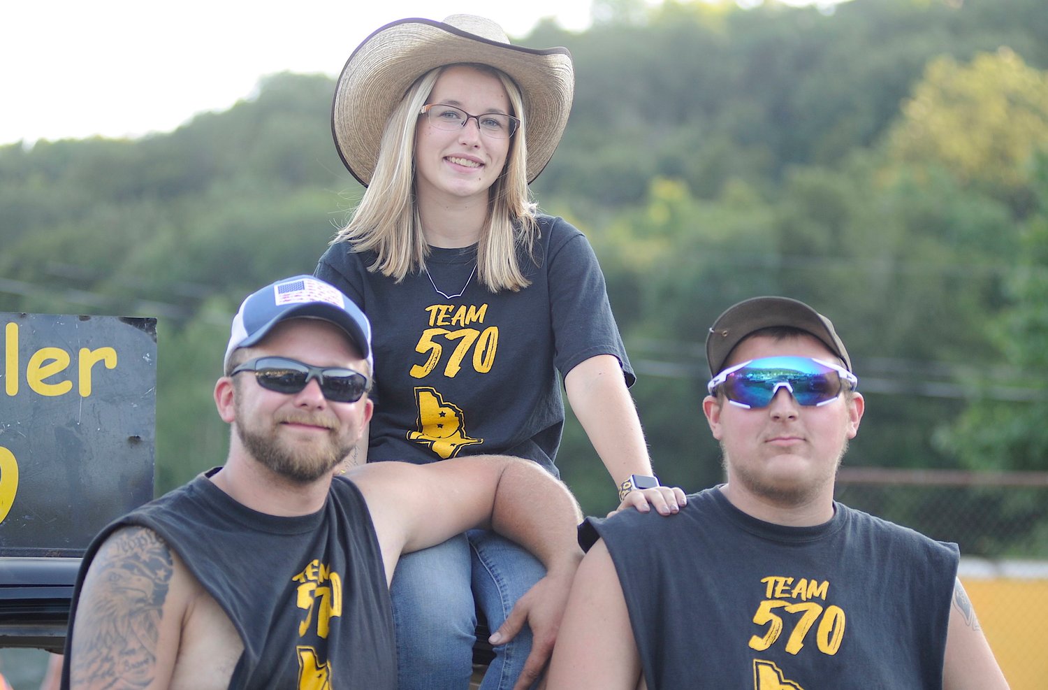 Riding high. Team 570 members and residents of Equinunk, PA, Johnny Smith and Johnathon Chrisler, pose with demo driver Kylie Chrisler...